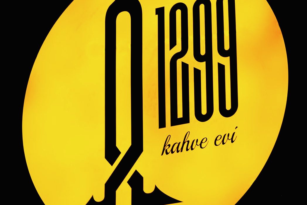 Sarı ışıklı panoda Ahlat 1299 kahve evi işareti.