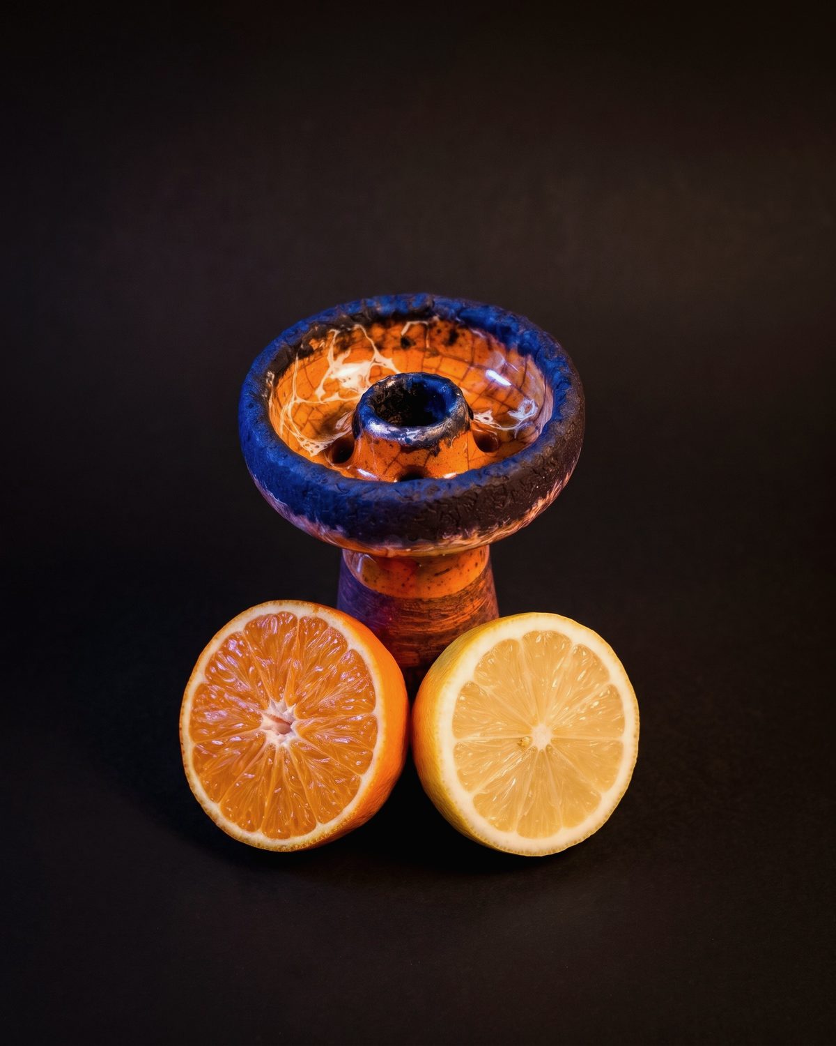 Mavi ve turuncu sırlı lüle; yanında yarım portakal ve limon.